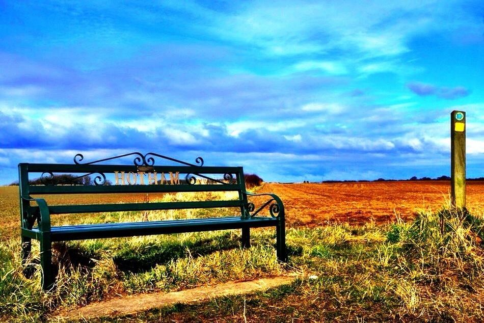 sky, cloud - sky, grass, cloud, field, empty, cloudy, absence, blue, tranquility, nature, bench, tranquil scene, no people, outdoors, day, built structure, landscape, chair, scenics