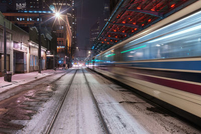 Blurred motion of train moving at railroad station platform during night