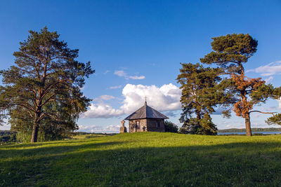 Wooden chapel and stone cross on the top of savkin hill, pushkinskiye gory reserve, russia 