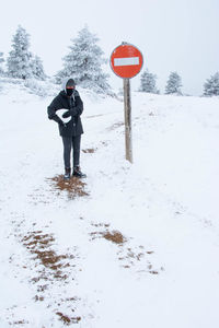 Rear view of man skiing on snow covered field