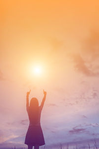 Rear view of silhouette man standing against sky during sunset