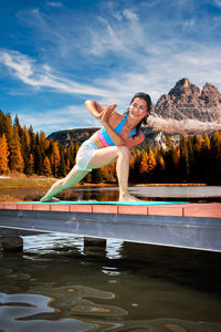 Woman standing on bridge at lake