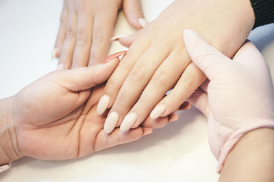 Cropped image of beautician holding hands at spa