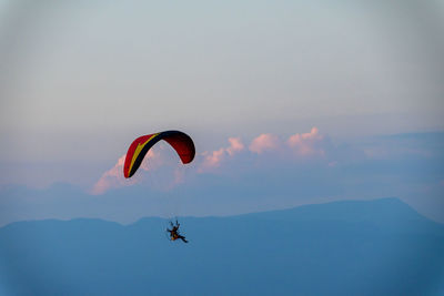 Person paragliding against sky