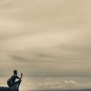 Silhouette man photographing against sky