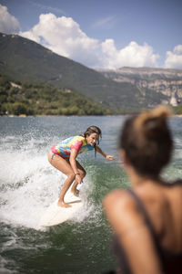 People enjoying in water against mountains