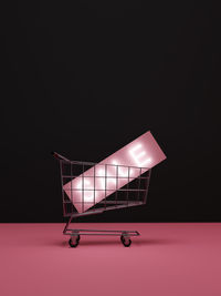 Close-up of shopping cart against black background