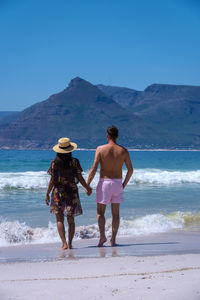 Rear view of woman standing at beach