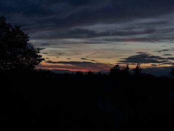 Silhouette trees against sky at sunset