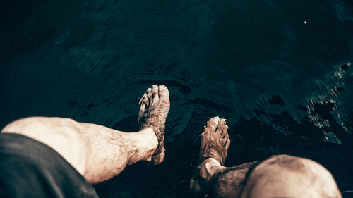 Low section of man relaxing in lake