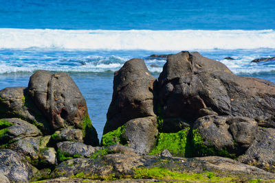 Scenic view of rocks on beach against sky