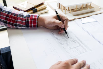 Cropped image of architect making blueprint in office