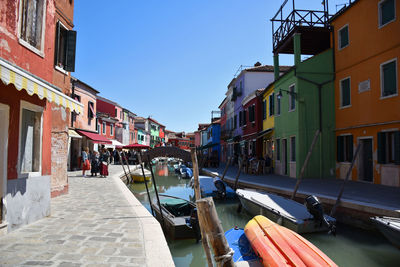 Canal amidst buildings in city against clear sky