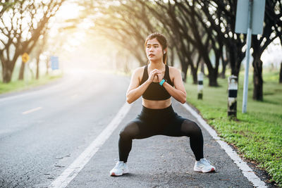 Side view of young woman exercising in park