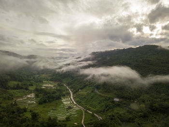 Aerial view of a village in the lush green rain cloud cover tropical rain forest mountain