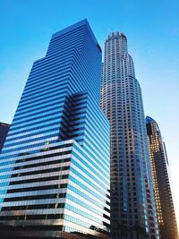 Low angle view of skyscrapers against blue sky