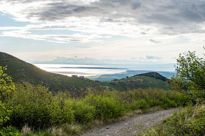 Scenic view of land and sea against sky