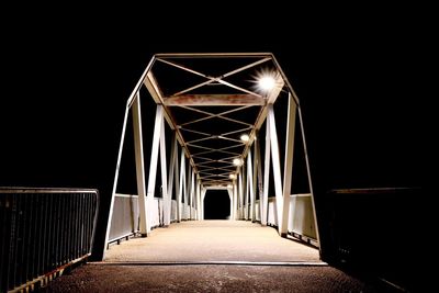 Empty illuminated bridge against clear sky at night