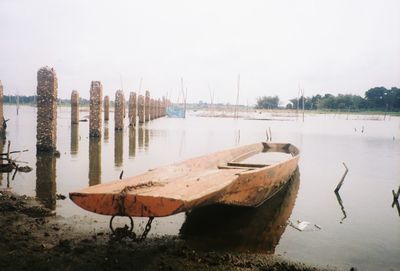 Boats moored on shore against sky