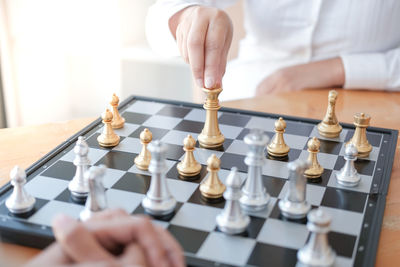 Midsection of people playing chess