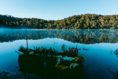 Scenic view of lake against clear blue sky