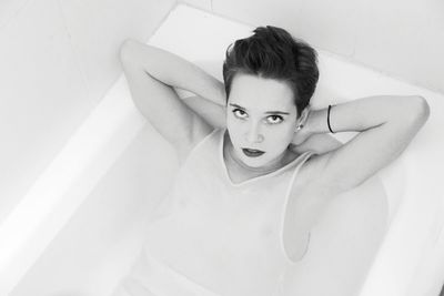 High angle portrait of fashion model bathing in bathtub at home