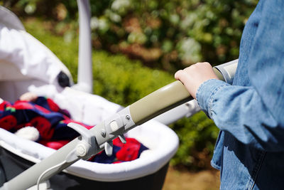 Midsection of woman holding hands on stroller