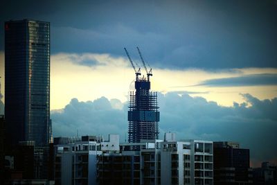 View of skyscrapers against cloudy sky