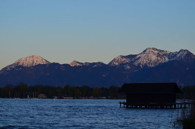 Scenic view of lake and mountains against clear sky