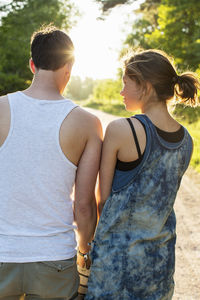 Rear view of couple standing against bright sun