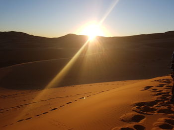 Scenic view of desert against sky during sunset