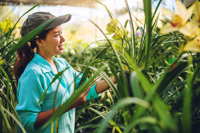 Female researcher examining flowers in greenhouse