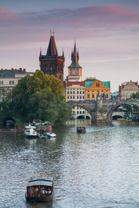 Boats in river with buildings in background