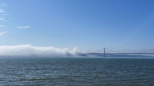 Suspension bridge over sea against sky