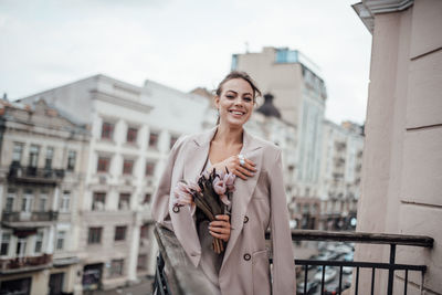 Full length of a young woman using mobile phone in city