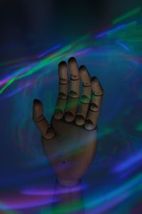 Close-up of human hand against colored background