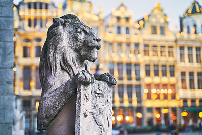 Statue of woman with buildings in city