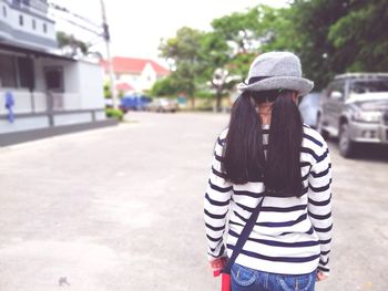 Rear view of woman standing on road