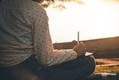 Low section of woman sitting outdoors