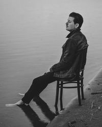 Side view of young man sitting on beach