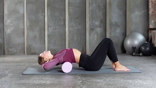 Low section of woman standing against wall