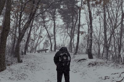 To climb a snowy mountain, a mountaineer wears black clothes and climbs the mountain.