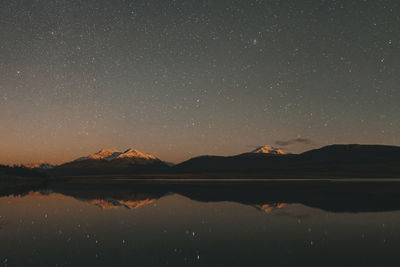 Scenic view of lake against sky at night