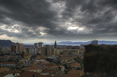View of cityscape against cloudy sky