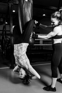 Women on boxing training doing crunches on punching bag