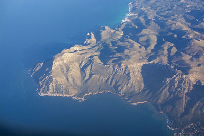 Aerial view of snowcapped mountains and sea against sky