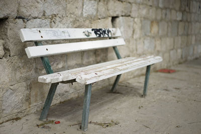 Empty bench against wall