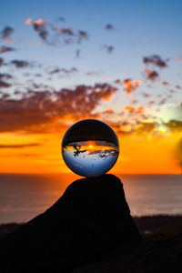 Close-up of silhouette crystal ball against sky during sunset