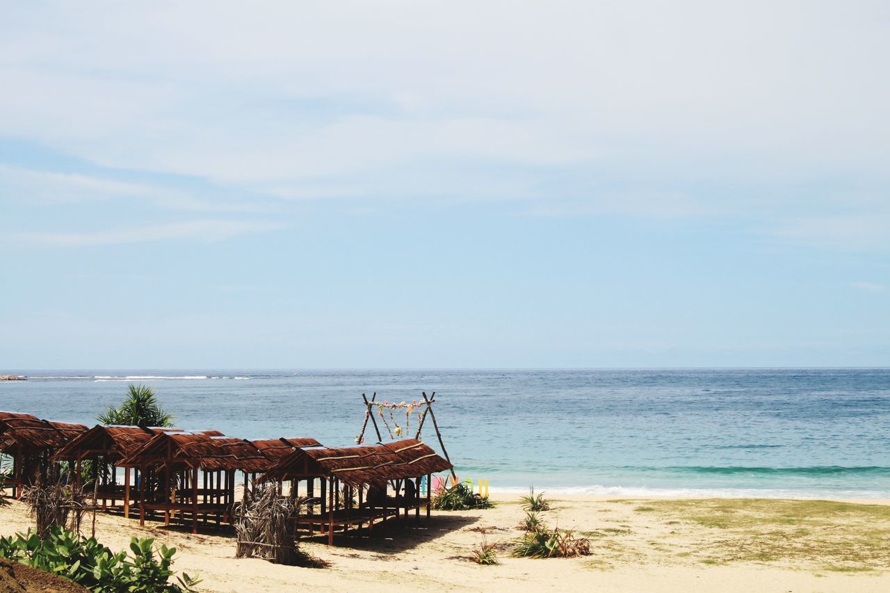 DECK CHAIRS ON BEACH AGAINST SKY