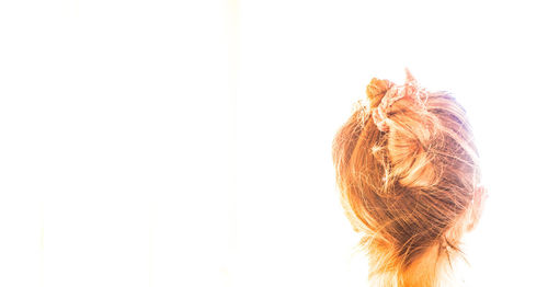 Rear view of woman hair bun against white background